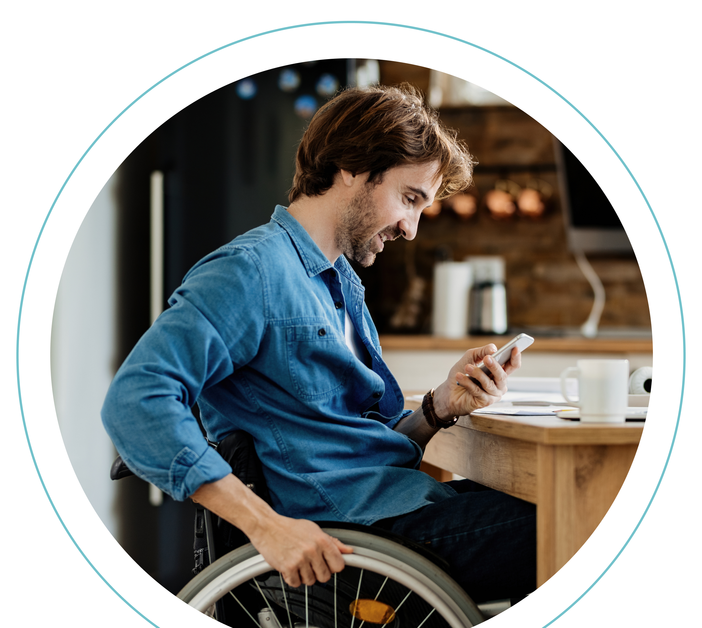 Un hombre en silla de ruedas se sienta a la mesa de la cocina, sonriendo mientras mira su smartphone. Siguiendo las normativas y principios de accesibilidad, el espacio está cuidadosamente dispuesto con papeles, un cuaderno y una taza de café sobre la mesa.