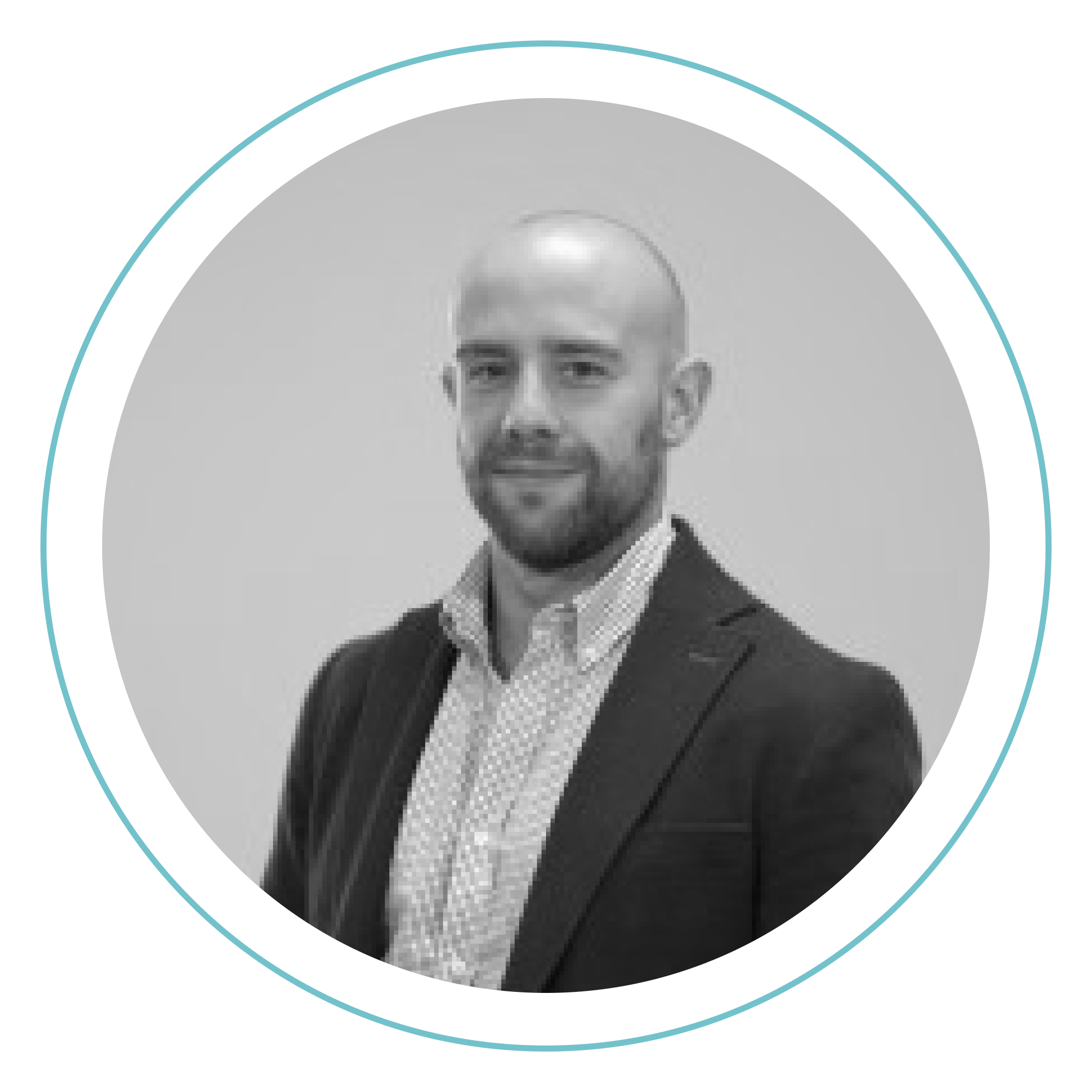 Retrato en blanco y negro de un hombre con la cabeza afeitada y barba corta, vestido con camisa estampada y americana oscura, mirando a la cámara y sonriendo ligeramente. Está dentro de un marco circular con borde azul claro.