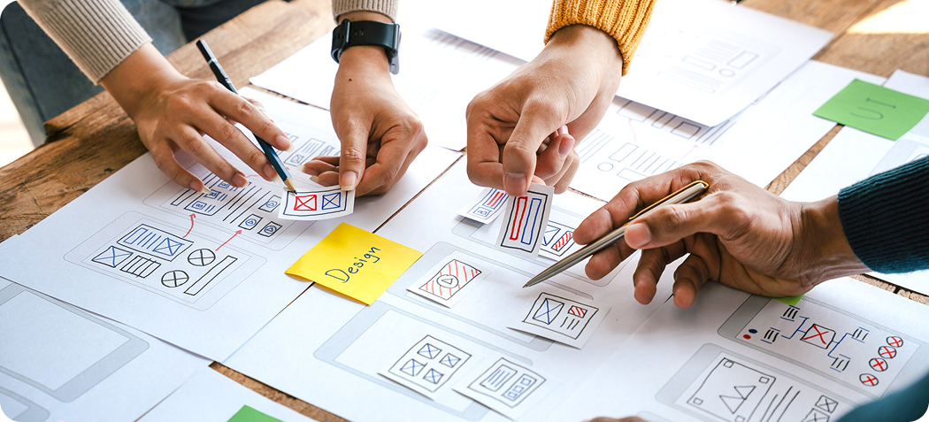Varias manos sujetando carteles que hacen referencia a sistemas de diseño