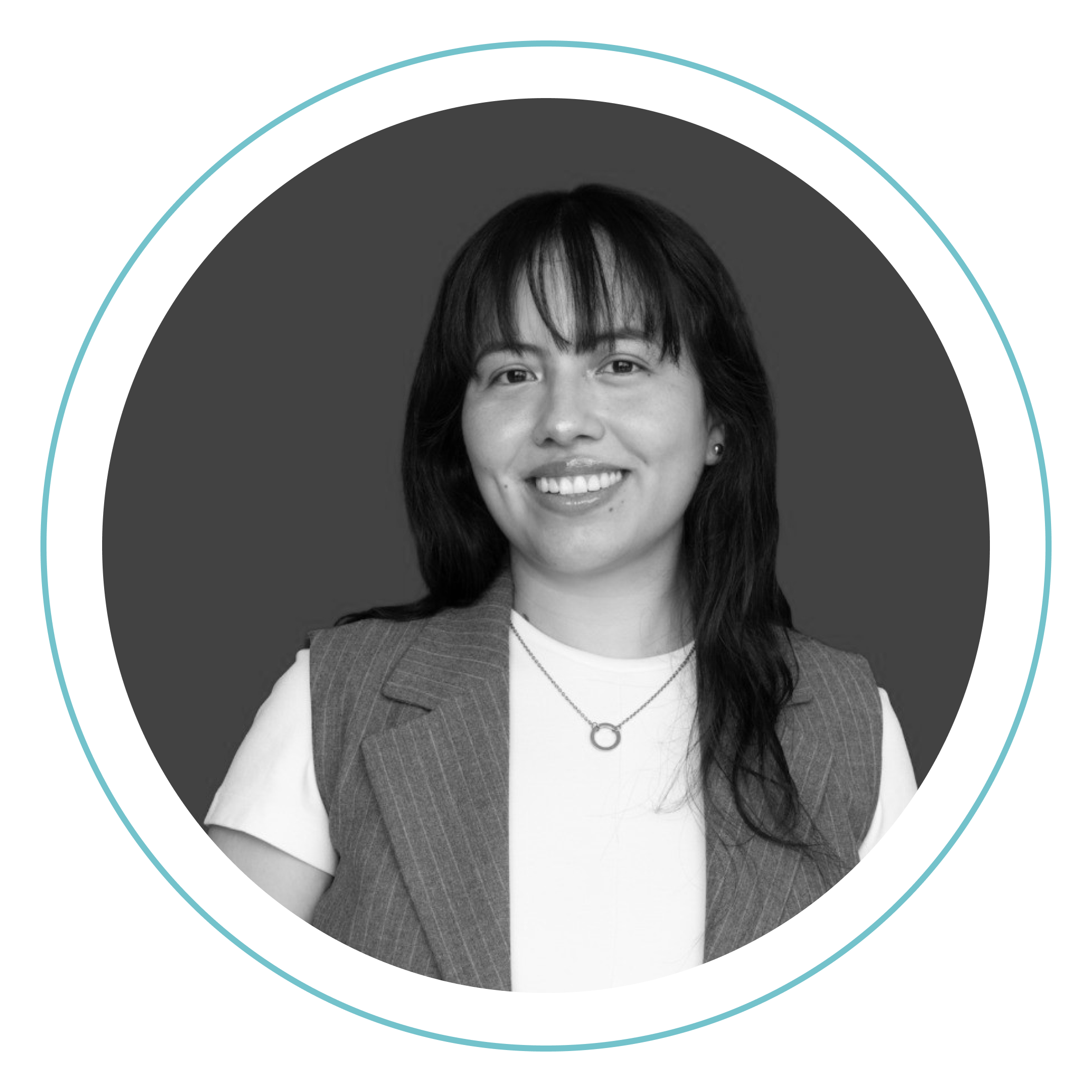 Retrato en blanco y negro de una persona de pelo largo y oscuro sonriendo, con camisa blanca, chaleco y collar, centrado dentro de un marco circular con borde azul claro.