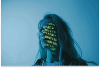 Una persona con el pelo largo se encuentra de pie bajo una luz azul, con un código binario verde proyectado en su cara, evocando el impacto de la AI en el diseño de productos y servicios UX/UI en un ambiente futurista y digital.