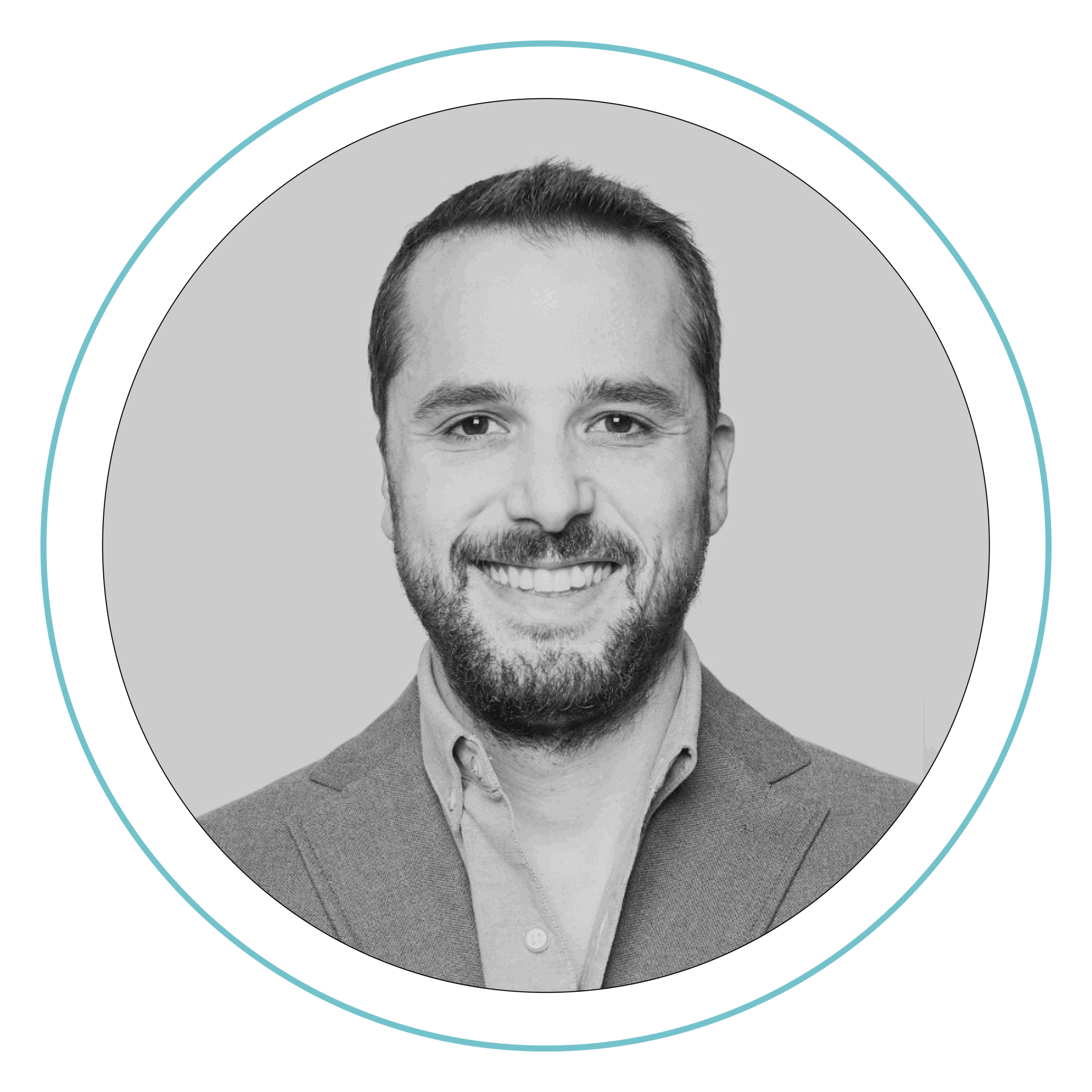 Fotografía en blanco y negro de un hombre con el pelo corto y barba, vestido con chaqueta de traje y camisa de cuello, que sonríe a la cámara. La imagen está enmarcada por un borde circular.